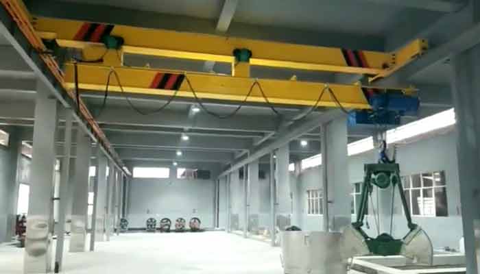 Telescoping bridge top running overhead crane used for low headroom workshop to improve vertical space 