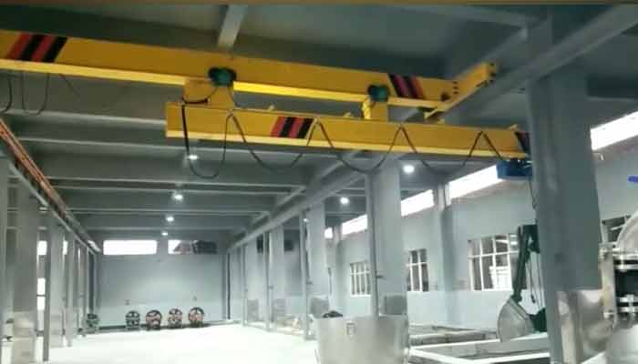 Telescoping bridge top running overhead crane for low headroom facility 